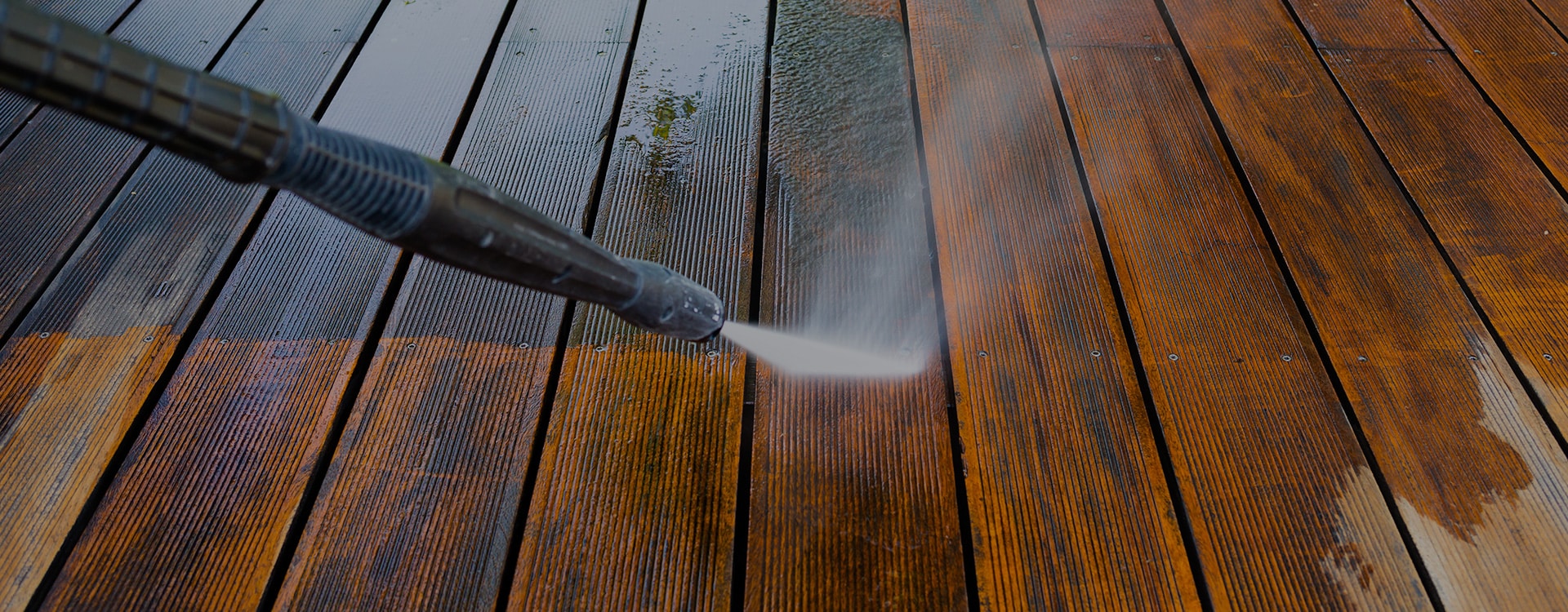 wood deck boards being power washed with water